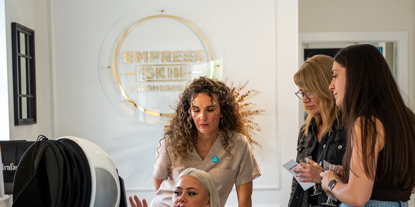 A practitioner talking through results with clients at Empress Skin